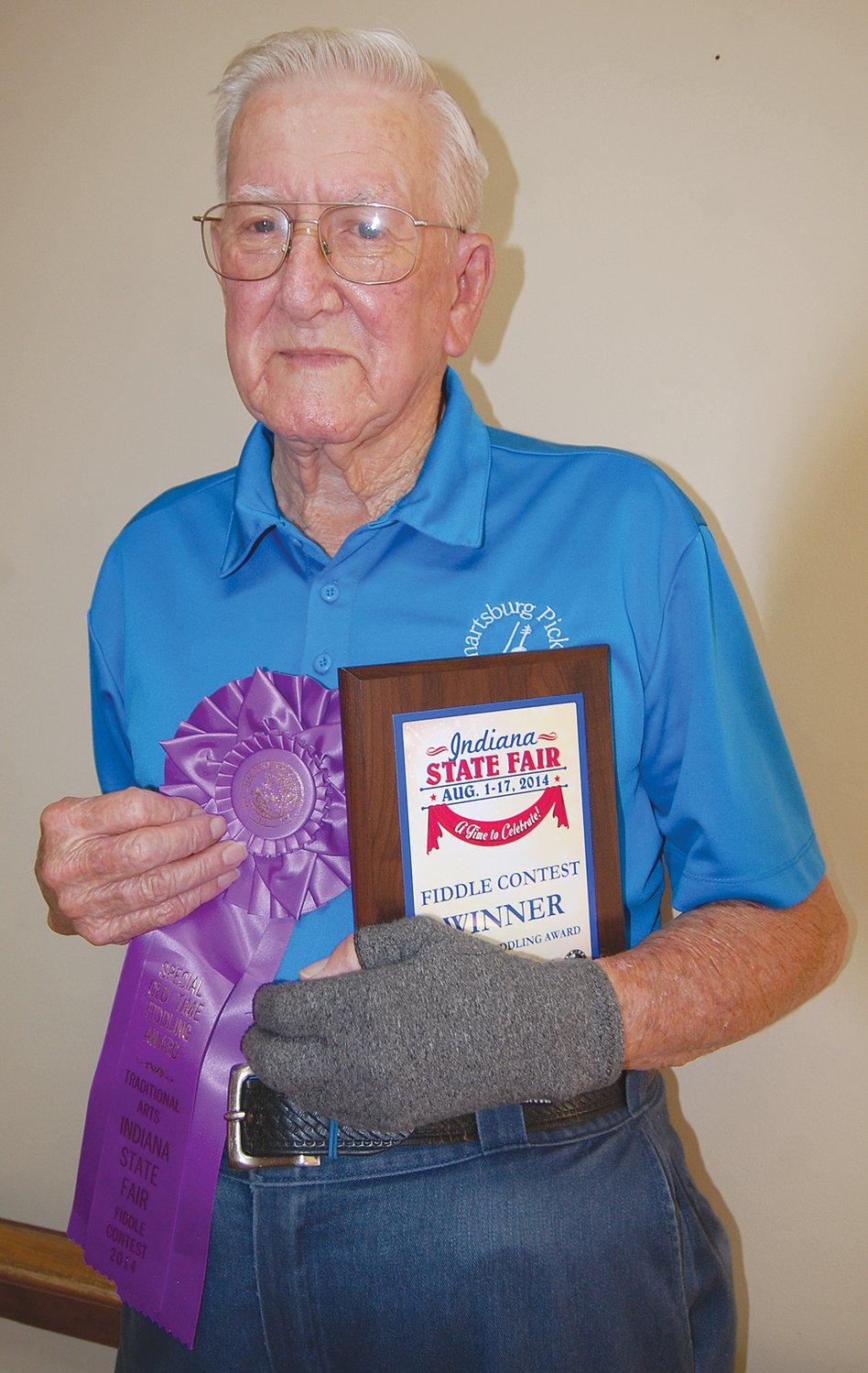 Archie Krout poses with his ribbon and plaque that he was awarded at the Indiana State Fair for his fiddle playing in 2014.